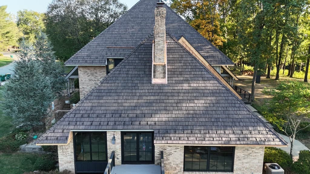 High-angle view of cedar shake roof texture, chimney, and perimeter snow guards