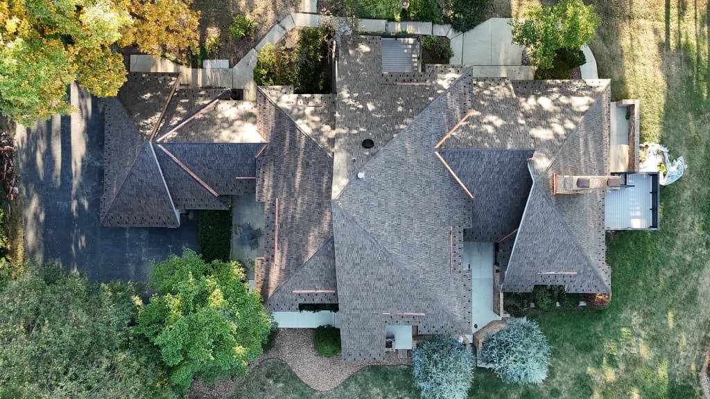 Overhead aerial of cedar shake roofing with copper ridges and complex roof geometry